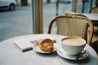 Café au Lait auf einem Tisch mit Corissant und Zeitung