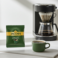 Jacobs Krönung 80x60 Filterkaffee Portionsbeutel für Gastro und Büro vor Kaffeemaschine